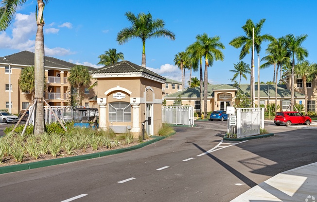 A street view of a residential area with palm trees and houses.
