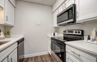 a kitchen with white cabinets and stainless steel appliances