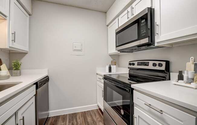 a kitchen with white cabinets and stainless steel appliances