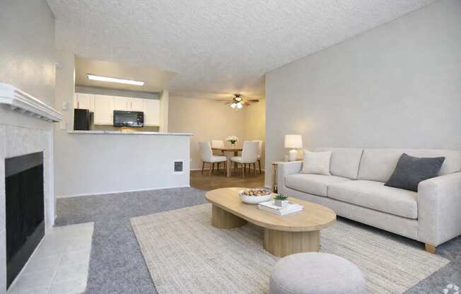 A living room with a fireplace, a couch, a coffee table, and a dining table.