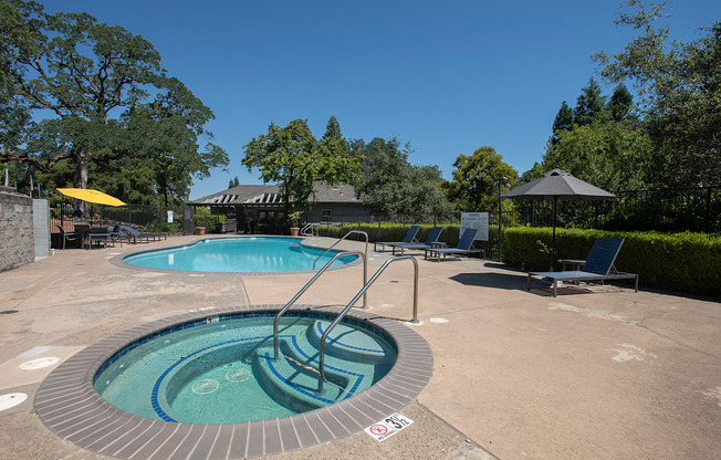 A hot tub sits in the middle of a patio surrounded by trees at Rocklin Gold Apartments, California, 95677