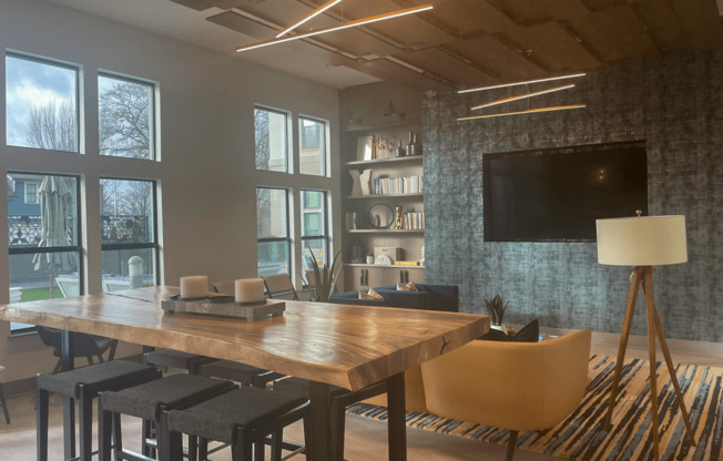 a room with a table and chairs and a flat screen tv on the wall at Link Apartments® Canvas, Atlanta, GA