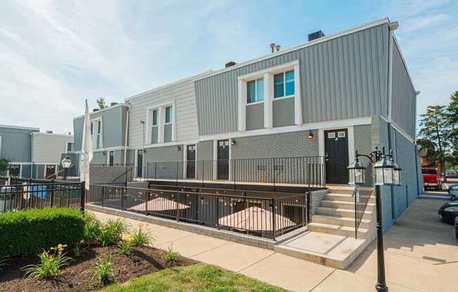 the exterior of an apartment building with stairs and a sidewalk