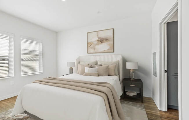A bedroom with a large bed and a painting on the wall.