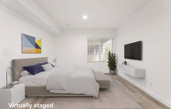 A bedroom with a bed, a couch, a television, and a painting on the wall.