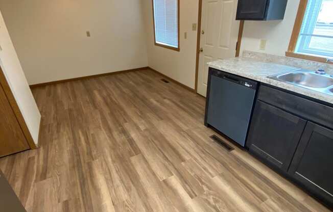 an empty kitchen with wood flooring in an empty house. Fargo, ND Sheyenne Terrace