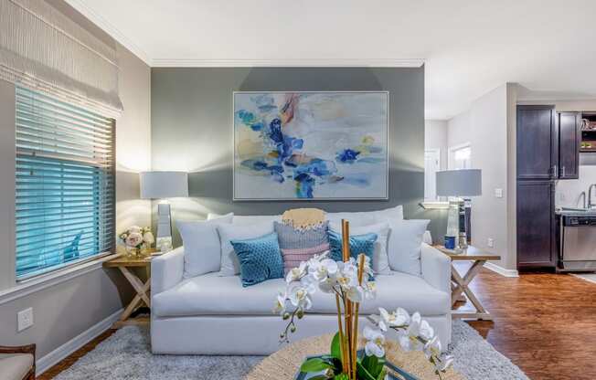 a living room with a couch and a table with flowers