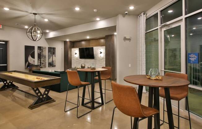 a game room with tables and chairs and a pool table