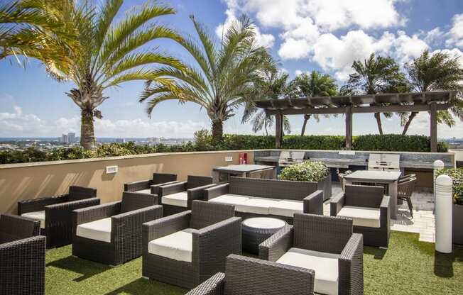 a lounge area on the roof of a building with chairs and tables