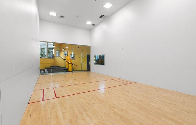 a basketball court in the center of a white room with wood floors and a yellow