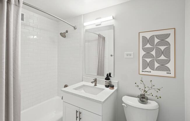 a bathroom with a toilet sink and shower and a mirror