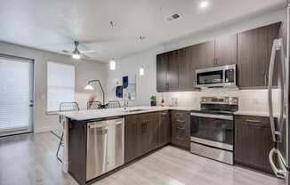 an open kitchen with stainless steel appliances and wooden cabinets