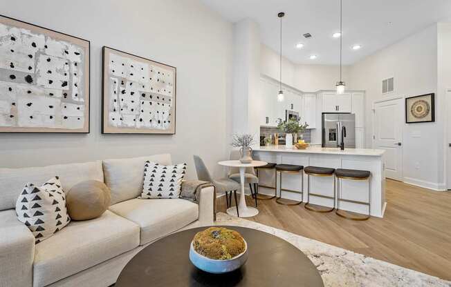 A modern living room with a white couch and a coffee table with a bowl of food on it.
