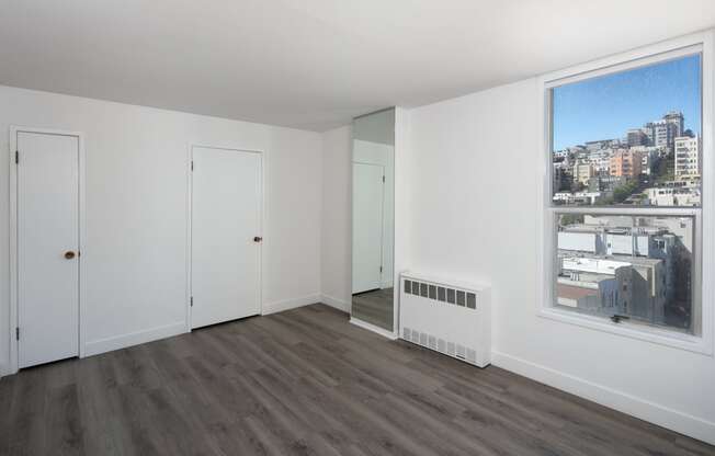 a bedroom with hardwood floors and white walls
