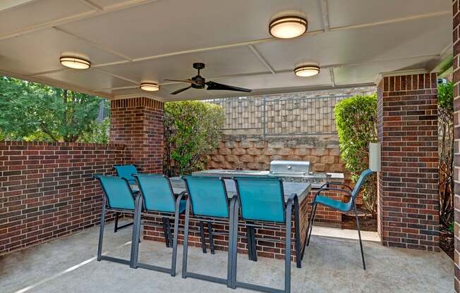 a patio with a table and chairs and a ceiling fan