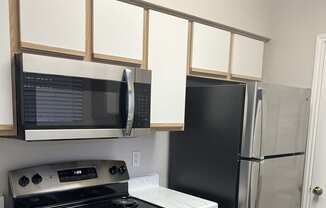 a kitchen with a stove and a microwave and some drawers