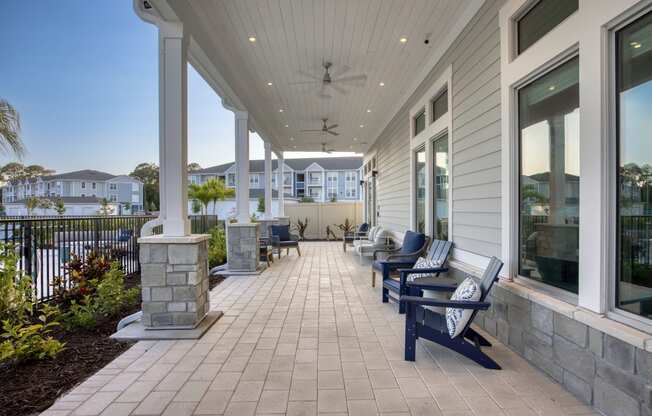 the front porch of a home with benches and a view of the water