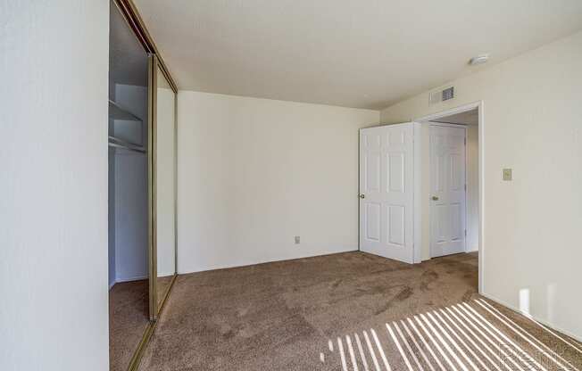 a bedroom with white walls and a carpeted floor at Terrace View Apartments, Daly City