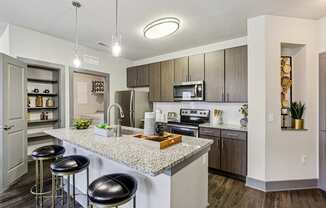 A kitchen with a granite countertop and bar stools.