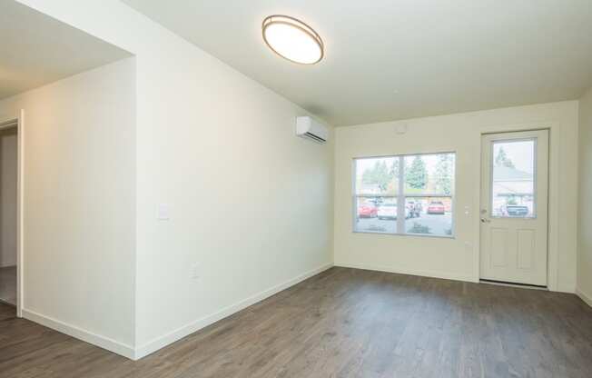 an empty living room with white walls and wood flooring