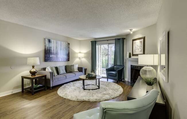 The Reserve at Bucklin Hill Apartments living room with a couch and a chair in front of a fireplace
