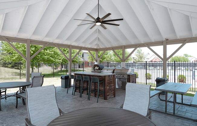 a patio with a table and chairs and a grill