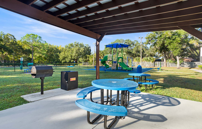 Community pergola and picnic tables next to community playground at Seven Lakes at Carrollwood in Tampa, Florida.