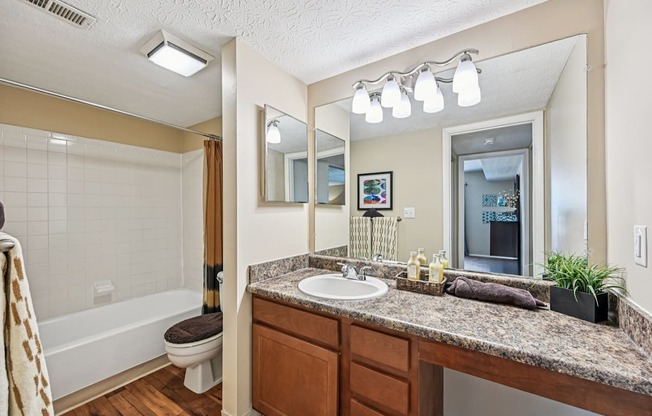 A bathroom with a brown countertop and a white sink.