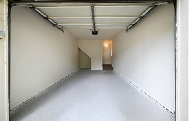 a empty room in a garage with a white wall