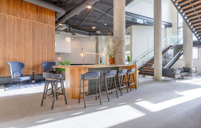 a bar area with stools and chairs and a staircase in the background at Marina Square, Bremerton