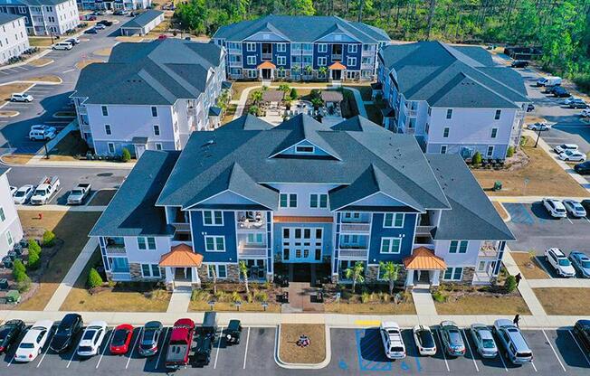 a large house with a parking lot full of cars