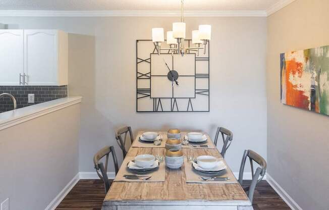 A dining room with a wooden table set for a meal.