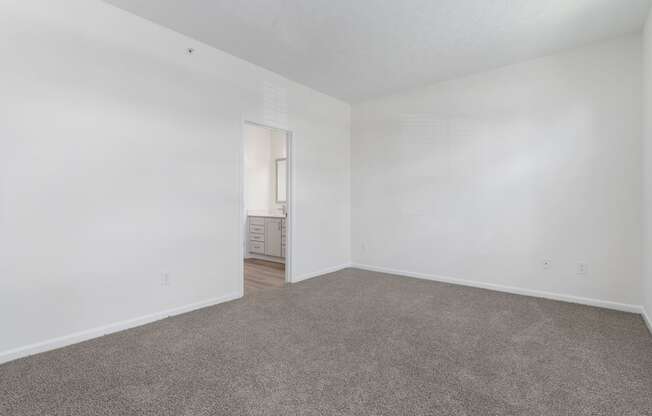 an empty living room with carpet and white walls