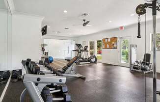 A gym with a variety of equipment including weights and machines.