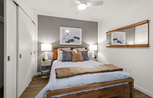 A bedroom with a bed, nightstands, and a ceiling fan.