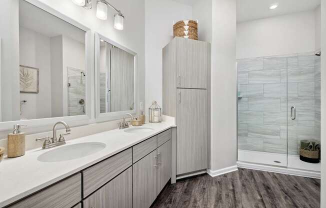 A bathroom with a white sink and a wooden cabinet.