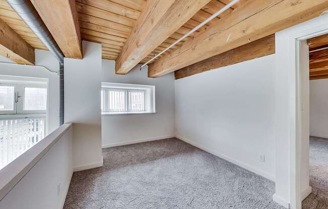 A room with a wooden ceiling and carpeted floor at Lowertown Commons Apartments, St. Paul, 55101