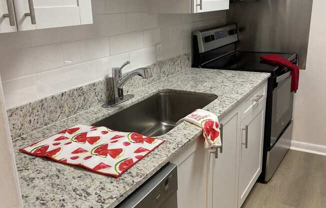 a kitchen with white cabinets and granite counter tops and a sink