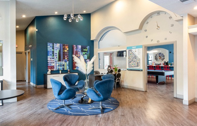 a lobby with blue chairs and a large clock on the wall