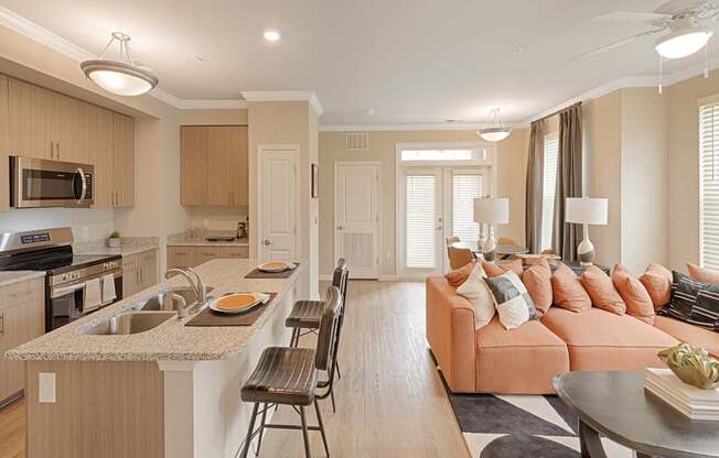 A kitchen with a counter top and a couch with pillows.