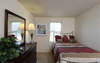 a bedroom with a bed and a dresser with a mirror