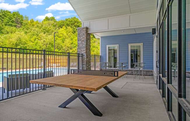 a ping pong table on the patio of a building with a pool in the background at The Lodge at Overland, Rochester, Minnesota