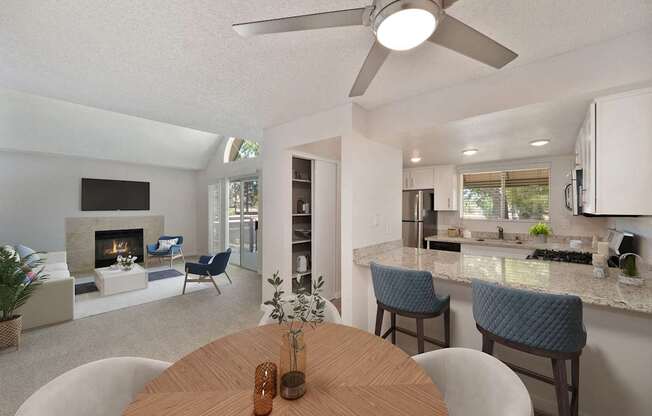 a living room and dining room with a table and chairs and views of the living room with fireplace