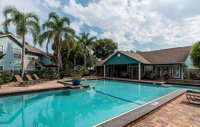 a large swimming pool with a house in the background