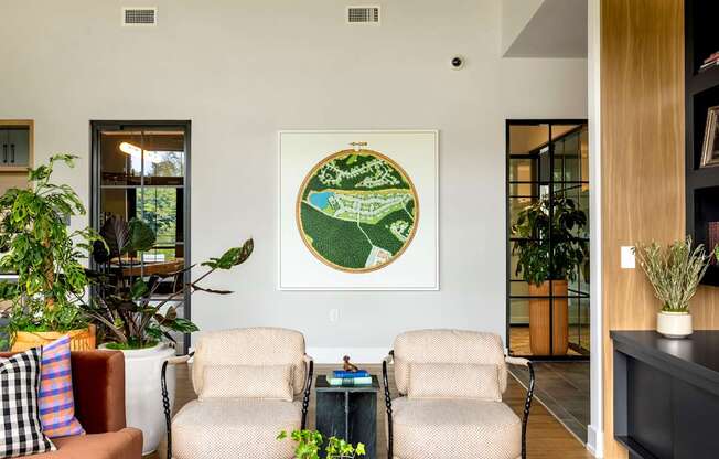 A living room with a rug, two chairs, a couch, and a painting on the wall.