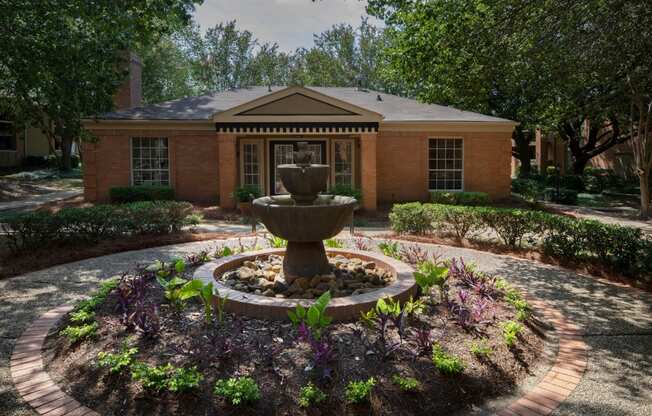 a fountain in front of a brick building