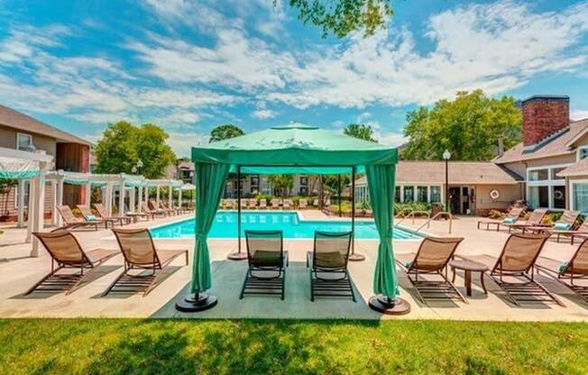 a swimming pool with a gazebo and lounge chairs