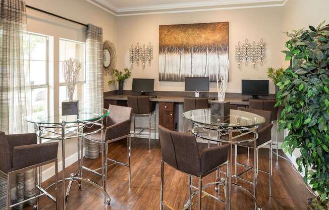 A modern home office with a glass table and chairs.