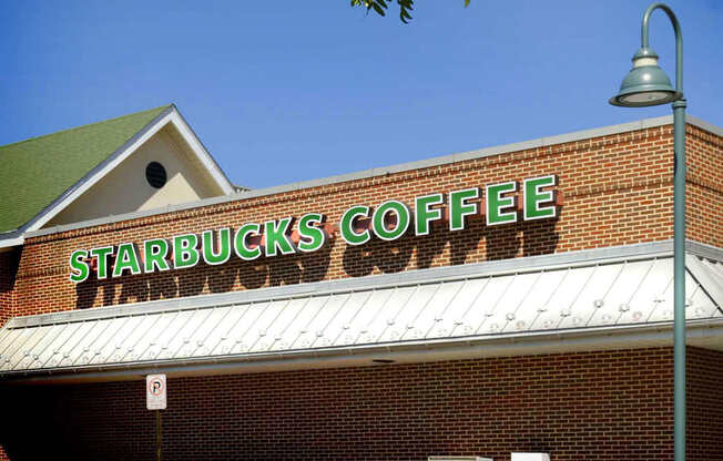 A Starbucks Coffee sign on a brick building.