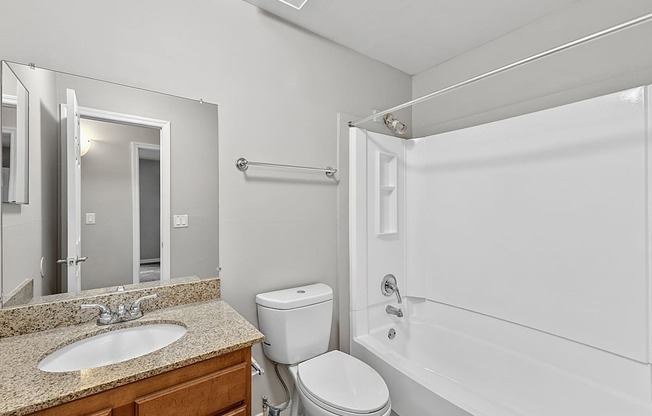 A white bathroom with a sink, toilet, and bathtub.